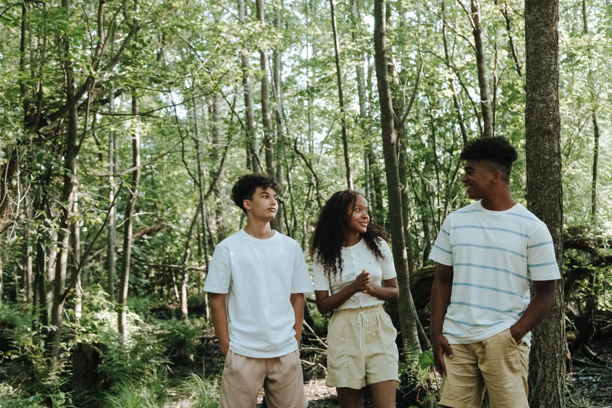 Teenagers walking and talking on a forest trail
