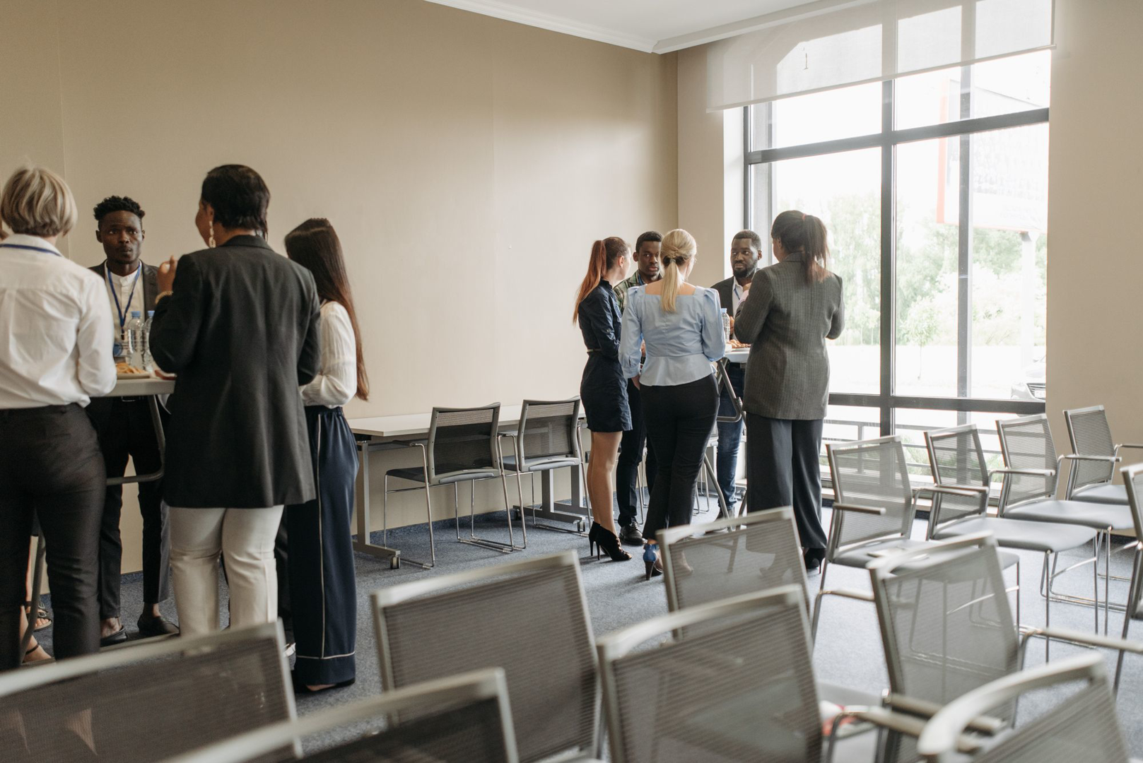 People gathered around tables in a bright meeting room